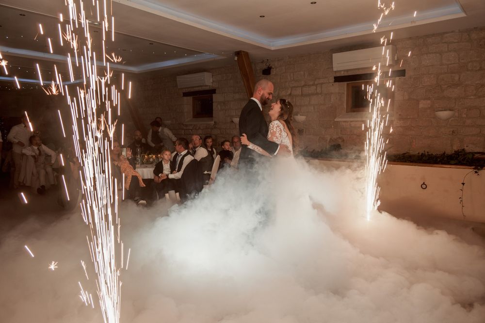 Première danse des mariés dans un nuage de fumée lourde, entre deux jets d'étincelles froides